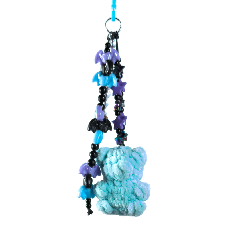Light blue crochet gummy bear keychain on a beaded chain of purple and black bats and stars