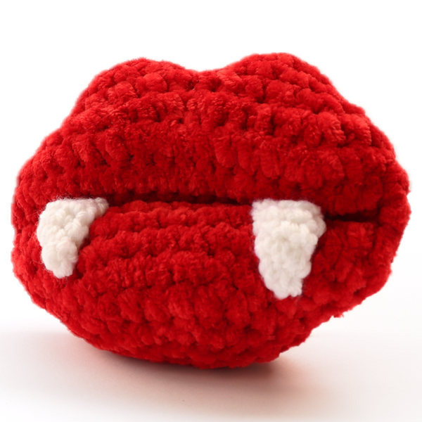 Hand-crocheted vampire lips plush with red lips and white fangs