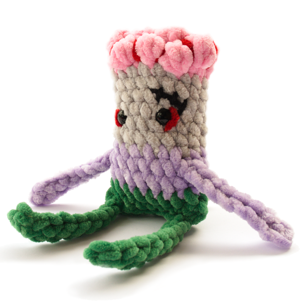 Hand-crocheted zombie plush with grey skin and green pants