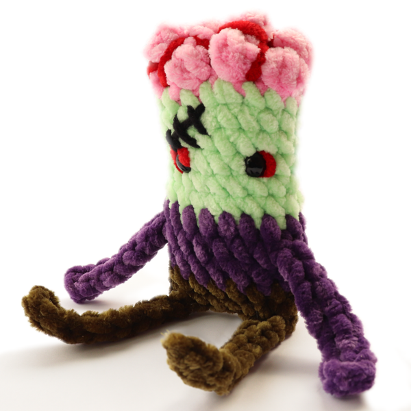 Hand-crocheted zombie plush with green skin and purple pants